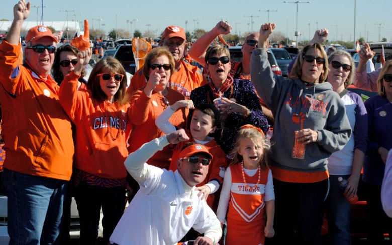 College football fans tailgating in Alabama with crimson and orange colors